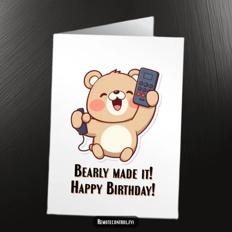 Funny free printable birthday card featuring a delighted bear holding a remote control upside down, looking pleased with his silly mistake.